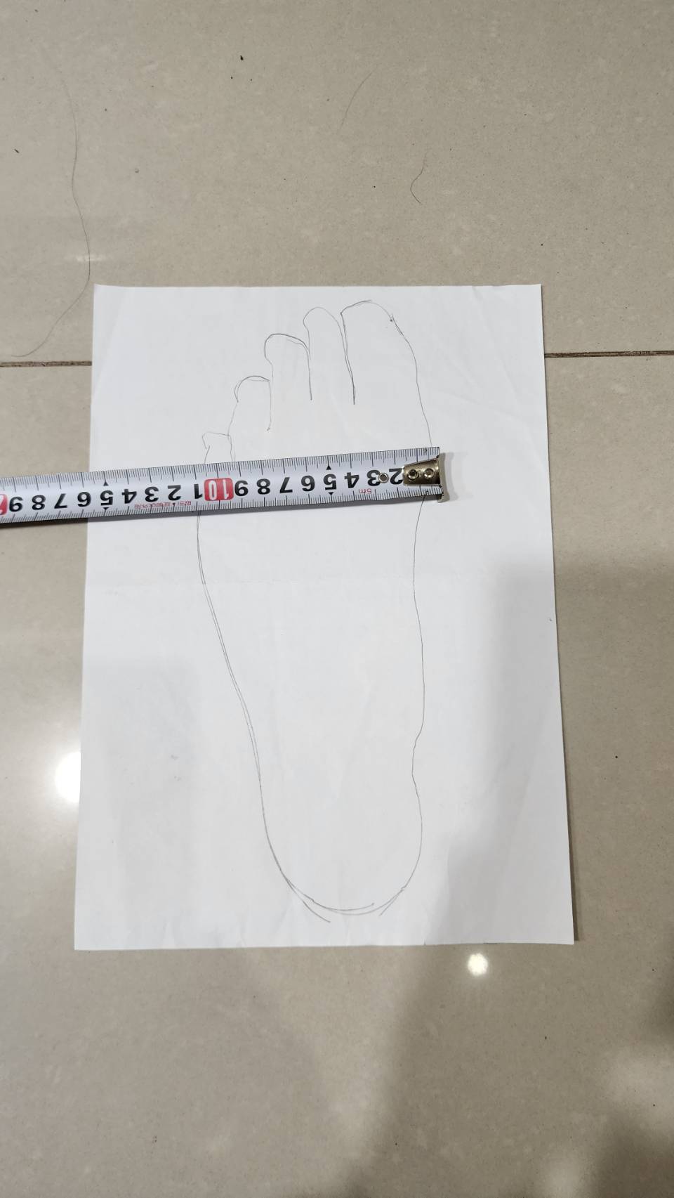 足部描繪量測前掌最寬處，捲尺顯示寬度數值